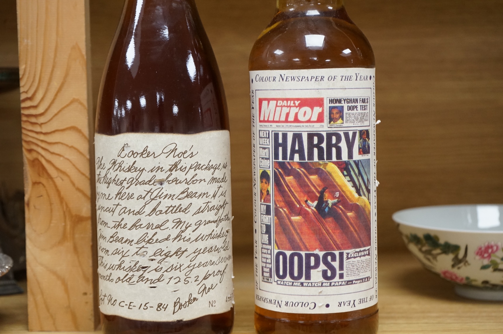 A bottle of ‘Daily Mirror’ Famous Grouse whisky and a bottle of Booker Noe’s Kentucky Bourbon Whiskey, bottled by James B. Beam Distilling Co.
